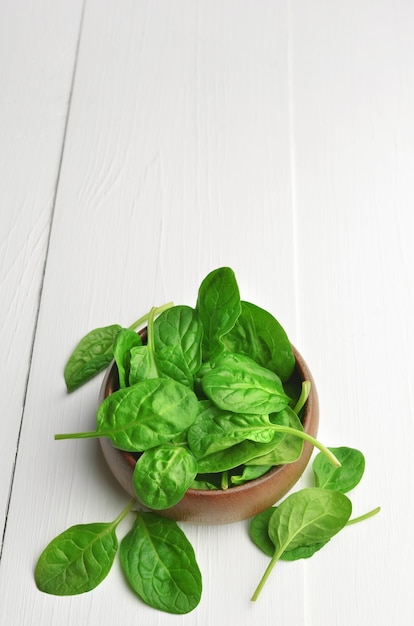 Foglie di spinaci freschi in ciotola di legno