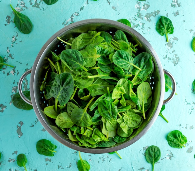 Foglie di spinaci verdi in una colapasta di ferro