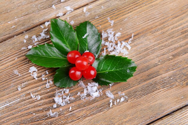 Foglie di vischio con bacche su fondo in legno