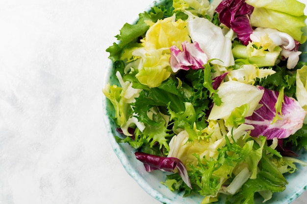 Foglie fresche di insalata diversa nel piatto di ceramica