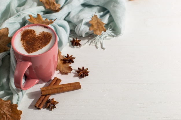 Foglie gialle secche, spezie, sciarpa blu, caffè con motivo a cuore sul tavolo, buongiorno è il miglior giorno d'inizio. Autunno umore sfondo, copyspace.