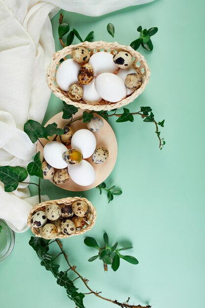 Foglie verdi e uova di Pasqua su una superficie verde