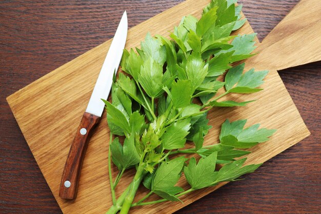 Foglie verdi fresche di lovage o Levisticum officinale su un tavolo da taglio di legno