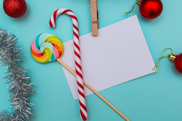 Foglio bianco per iscrizioni, caramelle, regali, giocattoli di Natale sull'azzurro