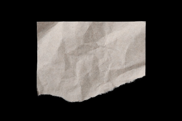 Foglio di carta beige stropicciato strappato isolato su sfondo nero black