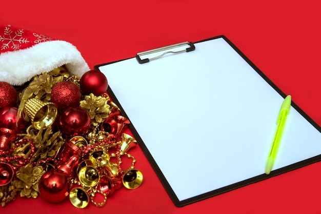 Foglio di carta bianco con accanto una penna con la pianificazione dei giocattoli di Capodanno