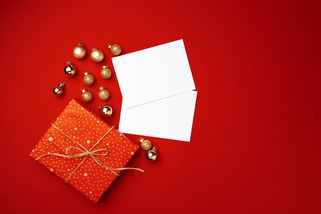 Foglio di carta bianco e regalo avvolto per la celebrazione del Natale su sfondo rosso