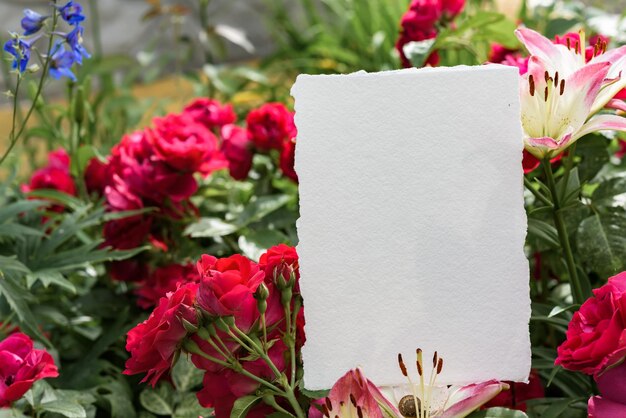 Foglio di carta bianco su sfondo floreale Fiori tropicali Mockup di invito a nozze