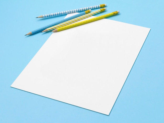 Foglio di carta con matite a strisce blu e gialle.