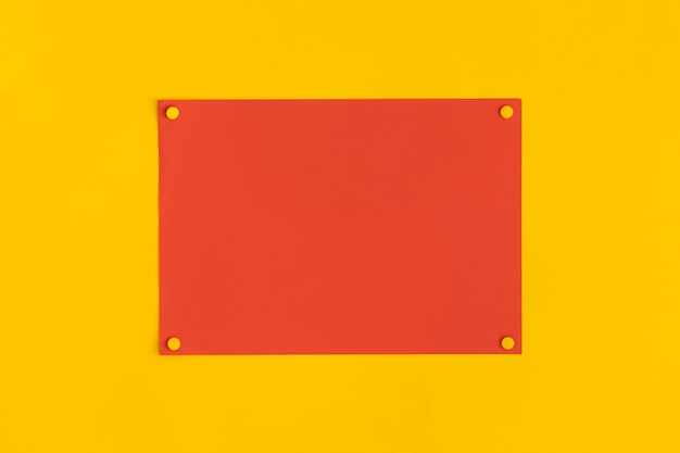 Foglio di carta con puntine con spazio per il testo su sfondo giallo.