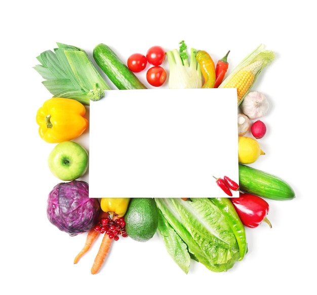 Foglio di carta e frutta e verdura colorate su sfondo bianco