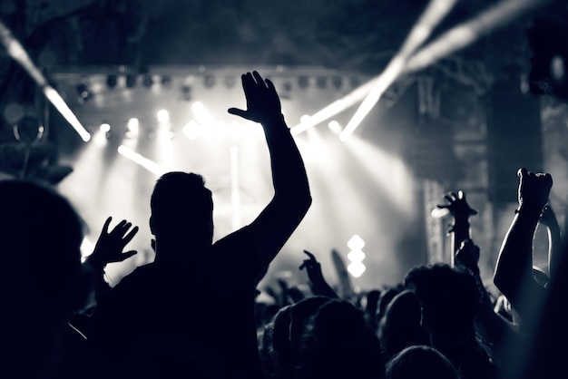 Folla a un concerto di musica con le mani alzate l'immagine tonificata