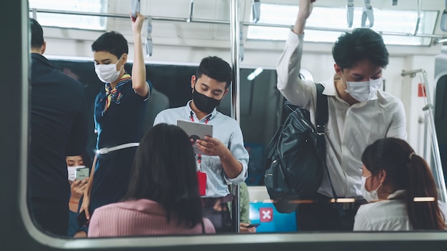 Folla di persone che indossano la maschera facciale su un affollato viaggio in metropolitana pubblica