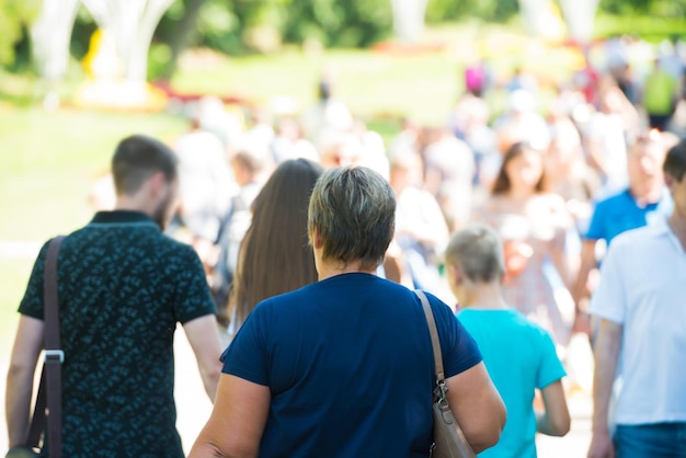 Folla di persone con donna anziana su una strada trafficata