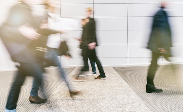 folla di persone sfocate anonime che camminano in una sala moderna