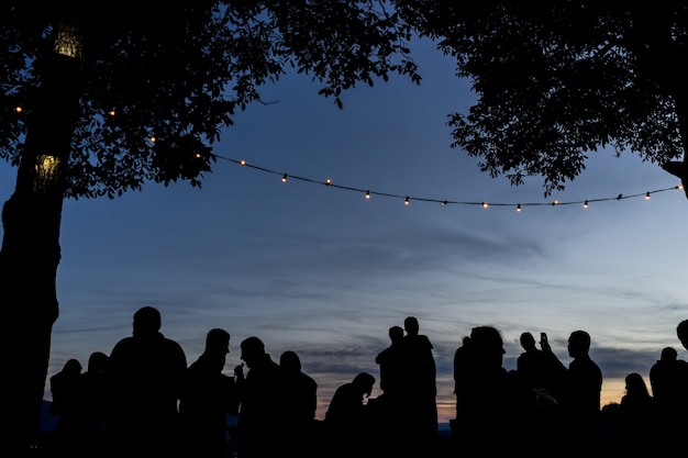 Folla persone insieme all&#39;aperto aspettando il tramonto