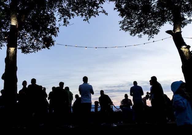 Folla persone insieme all&#39;aperto aspettando il tramonto