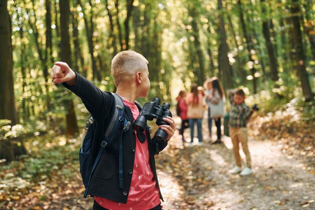 Fondare il modo I bambini nella foresta verde durante il giorno d'estate insieme