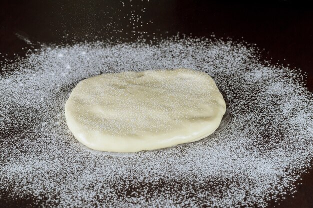 Fondente bianco sul tavolo da cucina scuro. Fare la decorazione della torta.