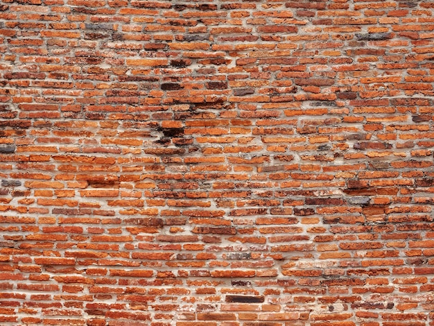 Fondo arancione antico del muro di mattoni