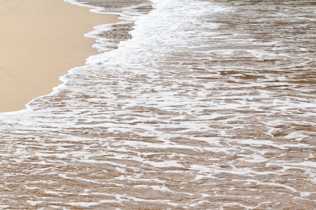 Fondo bagnato strutturato della spiaggia di sabbia