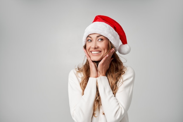 Fondo bianco dello studio del maglione del cappello di Sants di Natale della donna