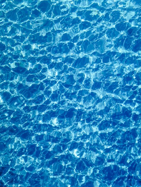 Fondo blu dell'acqua dell'ondulazione, riflesso del sole dell'acqua della piscina