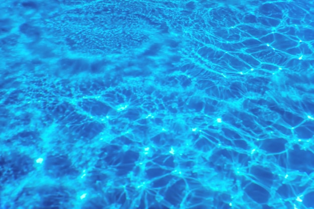 Fondo blu dell'acqua dell'ondulazione, riflesso del sole dell'acqua della piscina