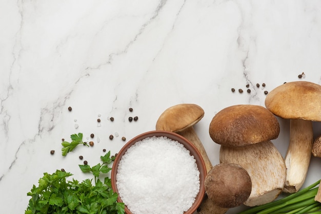 Fondo culinario con tavola di legno di funghi porcini e spezie su fondo grigio chiaro