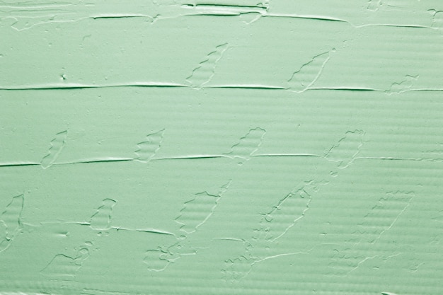 Fondo decorativo verde, struttura cremosa astratta. Muro di gesso, fondale con spazio libero per il testo.