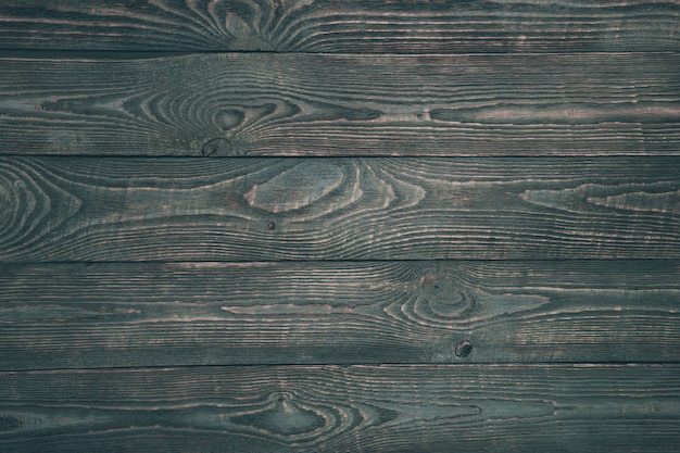 Fondo dei bordi di legno di struttura con i resti di pittura scura. Orizzontale.