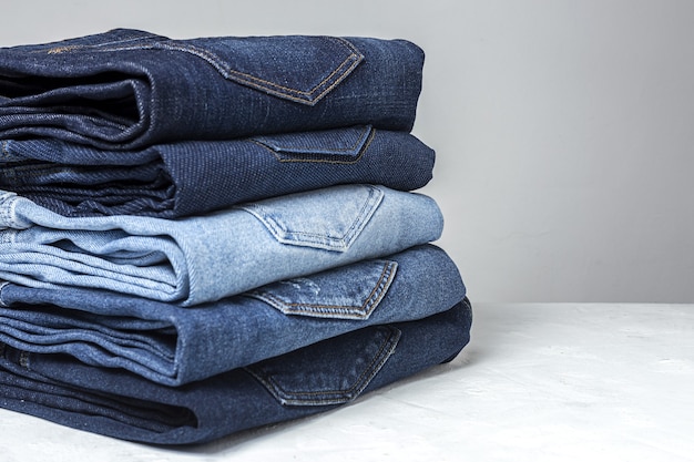 Fondo del mucchio dei vestiti dei pantaloni delle blue jeans. Dettaglio di bei blue jeans