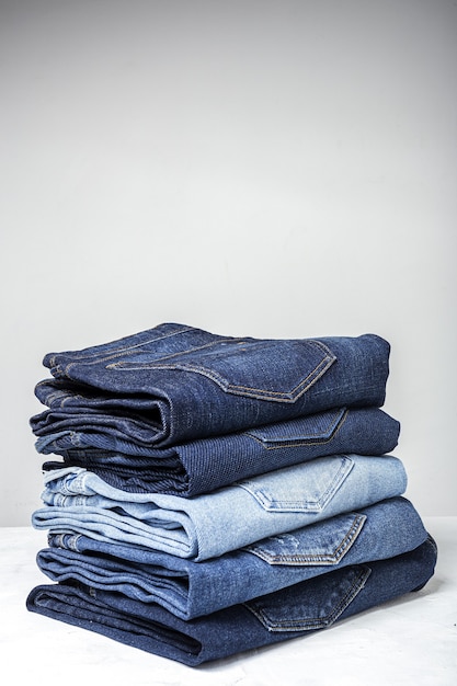 Fondo del mucchio dei vestiti dei pantaloni delle blue jeans. Dettaglio di bei blue jeans