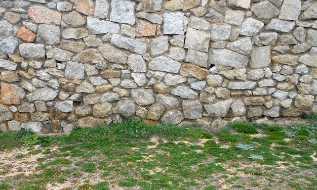 fondo del muro di pietra e pavimento dell&#39;erba