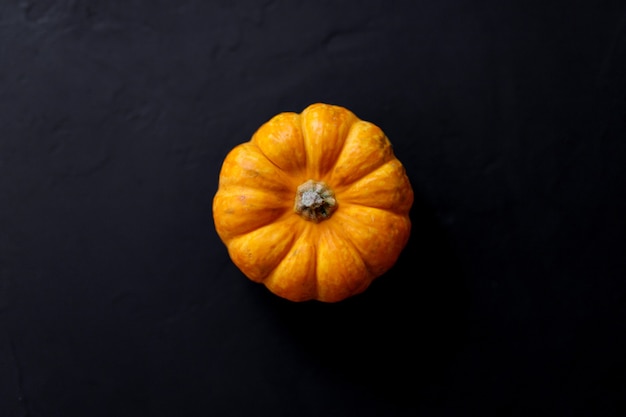 Fondo del Ringraziamento della zucca autunnale - zucche arancioni sul tavolo nero