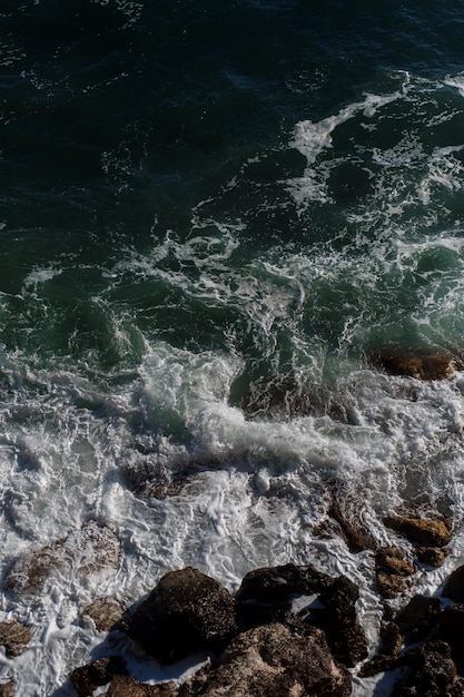 Fondo dell'onda dell'oceano che rompe la costa rocciosa dell'acqua di mare