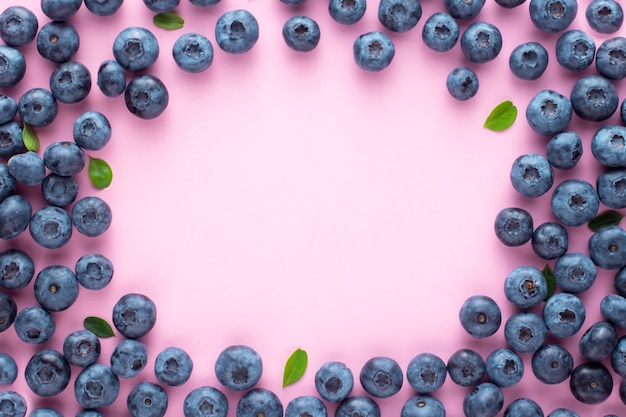 Fondo della bacca di estate della frutta dei mirtilli su un fondo rosa con il posto per testo, telaio.