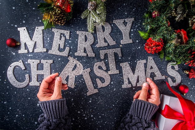 Fondo della carta di festa di Natale. Cappello da Babbo Natale con decorazioni di Natale e Capodanno, ghirlanda piatta su sfondo blu scuro, vista dall'alto