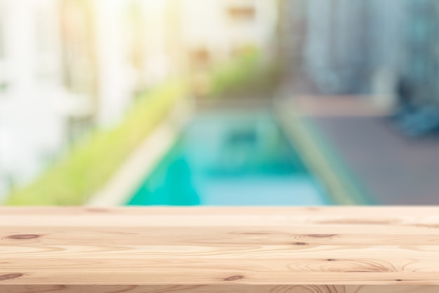 Fondo della piscina della sistemazione della sfuocatura con lo spazio della tavola di legno