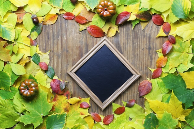 Fondo delle foglie di autunno a forma di cuore sulla tavola di legno