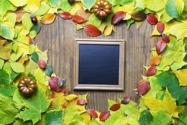 Fondo delle foglie di autunno a forma di cuore sulla tavola di legno
