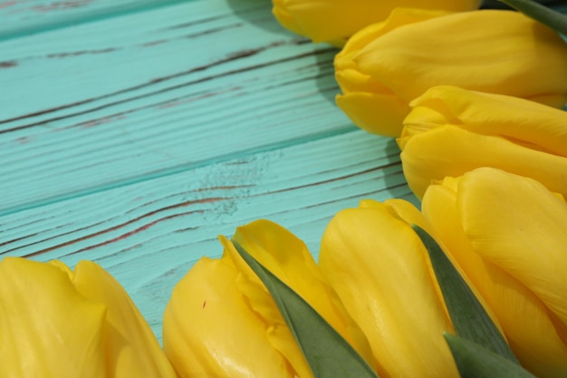 fondo di legno blu con i tulipani gialli e lo spazio della copia