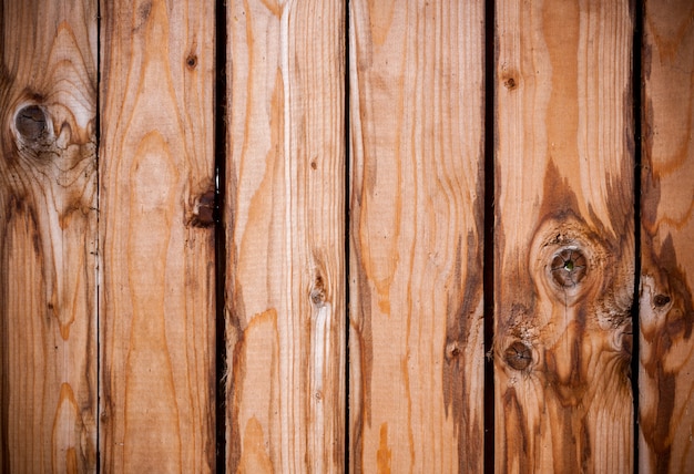 Fondo di legno dei bordi verticali marroni anziani con i nodi e le macchie.