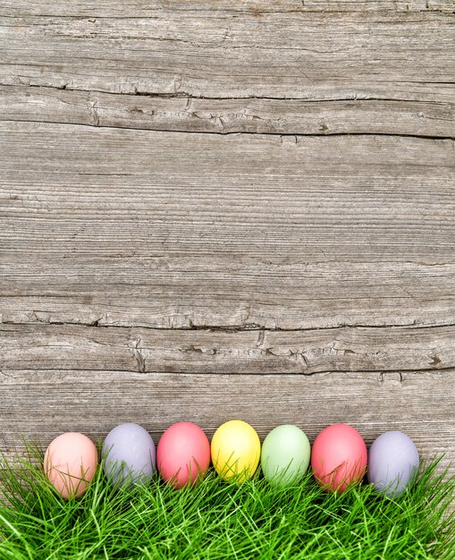 Fondo di legno dell'erba verde delle uova di Pasqua