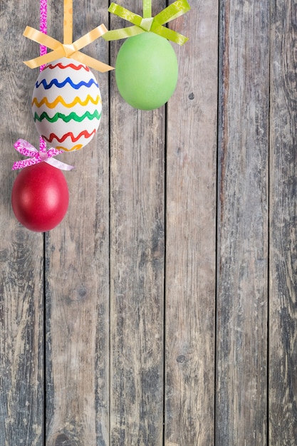 Fondo di legno di festa con uova dipinte, decorazione di primavera