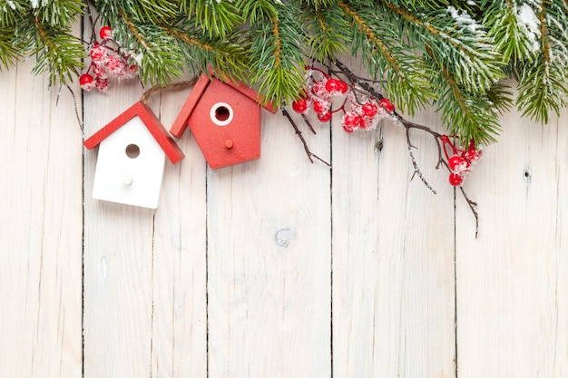 Fondo di legno di Natale con l'albero di abete e la decorazione della casetta degli uccelli