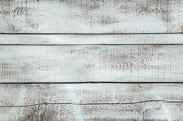 Fondo di legno grigio, bordi strutturati. Vecchio muro di legno dipinto. Plance orizzontali dipinte di legno dell'annata. Spazzolatura del legno