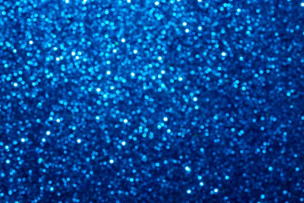 Fondo di Natale della stagnola blu di scintillio. Fondo defocused astratto di struttura della lamina blu del metallo lucido. Texture glitter scintillanti con luci bokeh.