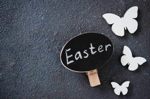 Fondo di Pasqua con le farfalle di legno decorative e l&#39;iscrizione Pasqua.