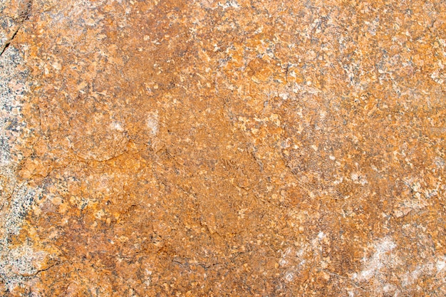 Fondo di struttura del granito marrone dorato giallo grezzo grezzo. Fondo di struttura di pietra naturale della roccia. Gradi di granito. Minerali color moscovita in granito